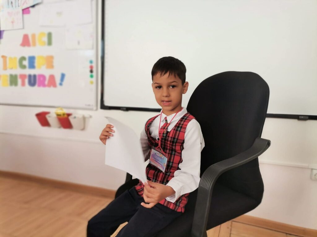 Elev în uniformă așezat la tablă